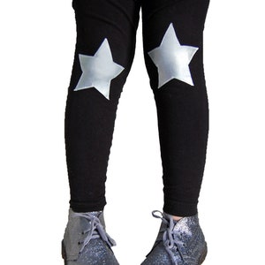May include: Black leggings with silver star accents on the knees. The leggings are paired with silver glitter ankle boots.