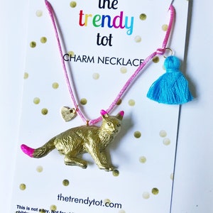 Kids gold cat necklace with pink string, blue tassel and gold heart charm.