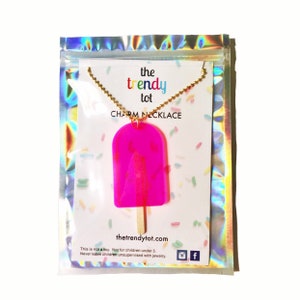 Hot pink translucent popsicle with no bite and real wooden popsicle stick in creative iridescent freeze-dried ice cream packaging. 24 inches long. Great for kids or adults.