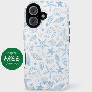 May include: White phone case with a blue seashell and starfish pattern. The case has a black camera module and a green circle with the words "ENJOY FREE" on the left side. The name "Jacqueline" is printed at the bottom.