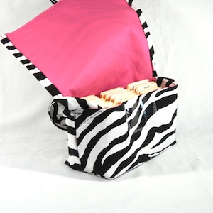 May include: A black and white zebra print fabric bag with a pink lining. The bag is open and has a clear plastic pocket on the front. The bag is filled with index cards.