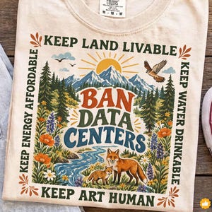 Może przedstawiać: Kremowy t-shirt z nadrukiem graficznym przedstawiającym górski krajobraz ze słońcem, sosnami, rzeką i dwoma lisami. Tekst brzmi: KEEP LAND LIVABLE, BAN DATA CENTERS, KEEP ENERGY AFFORDABLE, KEEP WATER DRINKABLE, KEEP ART HUMAN.