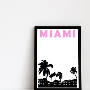May include: Black framed print with a white background and the word "MIAMI" in pink letters. The print features a black silhouette of palm trees and buildings.