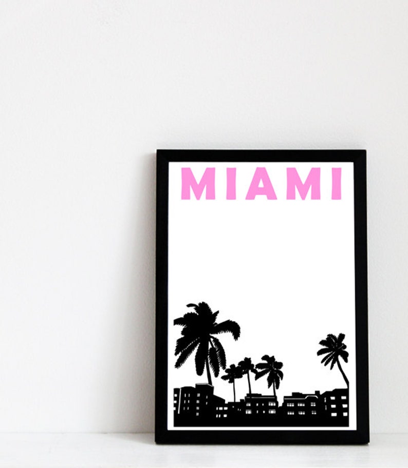 May include: Black framed print with a white background and the word "MIAMI" in pink letters. The print features a black silhouette of palm trees and buildings.