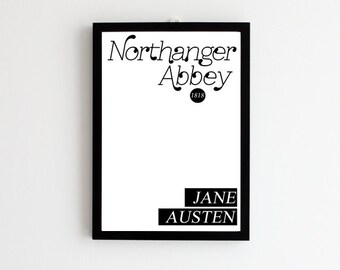 May include: Black and white framed print of the book title "Northanger Abbey" by Jane Austen. The title is in a stylized font and the year 1818 is printed below it.