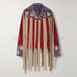 May include: A red suede jacket with vertical beige fringe and red stripes. The jacket features a purple collar and cuffs with beige star accents. The jacket has a button-up front and is a unique piece of apparel.