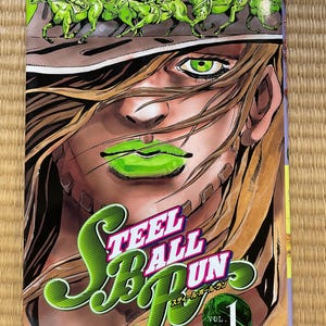 Puede incluir: Volumen 1 de la serie de manga Steel Ball Run, con una ilustración en verde y amarillo de una mujer con ojos y labios verdes. El texto "Steel Ball Run" está escrito en letras verdes y amarillas. El texto "Vol. 1" está escrito en letras negras y blancas sobre un círculo verde y amarillo.