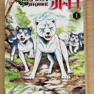 Könnte beinhalten: Manga-Cover mit drei stilisierten Hunden in einer Waldszene. Der zentrale Hund ist weiß, flankiert von zwei Hunden mit schwarz-grauen Markierungen. Japanischer Text und der Titel "Legend of Silver Fang" oben, mit der Nummer "1" in einem grünen Kreis.