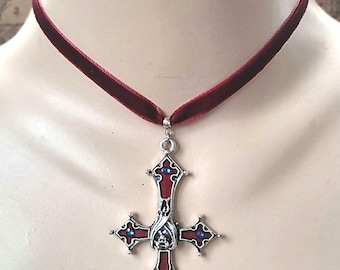 Könnte beinhalten: Burgunderfarbene Samt-Halskette mit einem silbernen Kreuzanhänger. Das Kreuz hat rote Emaille und blaue Edelsteinakzente. Der Text "Gothic-Fusion" befindet sich unten rechts im Bild.