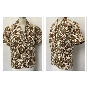 May include: A brown and white short-sleeved button-up blouse with a floral pattern.