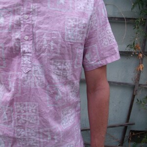 May include: A pink short-sleeved button-down shirt with a white geometric pattern.