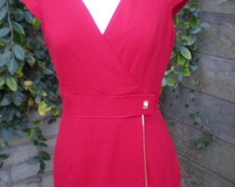 May include: A red wrap dress with a v-neck and a gold zipper detail.