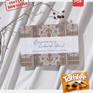 May include: A greeting card with a patterned design and the text "Bayramınız mübarek olsun!" is displayed on a white surface. A box of Toffifee chocolates is in the lower right corner. The card has a "PDF" icon.