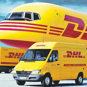 May include: A yellow DHL delivery van and truck are parked in front of a yellow and red airplane. The DHL logo is prominently displayed on the vehicles and the plane. The sky is blue.