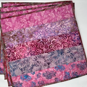 May include: Set of six purple and gray patterned fabric placemats. The placemats are made of a soft, cotton fabric and feature a variety of floral and geometric designs.
