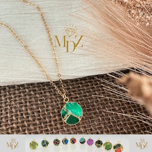 Può includere: Collana color oro con un pendente rotondo verde con venature color oro. Il pendente è il punto focale, sospeso a una delicata catena. L'immagine mostra anche una varietà di opzioni di pendenti e il logo "MDZ".