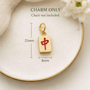 Op de afbeelding: Een goudkleurige, rechthoekige bedel met een rood Chinees karakter en een oogje aan de bovenkant. De bedel is 25 mm hoog en 8 mm breed. De tekst op de afbeelding luidt: CHARM ONLY, Chain not included, 25mm, 8mm.