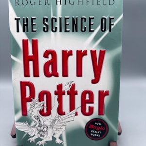 Puede incluir: Un libro verde titulado "The Science of Harry Potter: How Magic Really Works" de Roger Highfield. La portada presenta una ilustración blanca de un dragón.