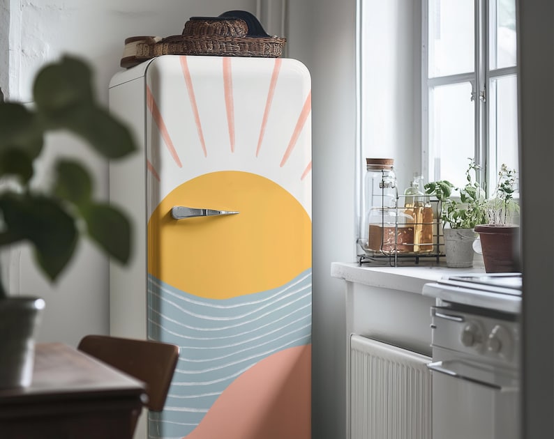 May include: A white refrigerator with a colourful sun and waves design. The design features a yellow sun with pink rays and blue waves.