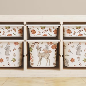 May include: Six white storage bins with lids, each featuring a different woodland animal print. The bins have a white background with brown, orange, and green accents. The prints include a deer, a rabbit, and leaves.