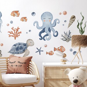 May include: A set of blue and orange watercolor ocean animal wall decals. The decals include a jellyfish, octopus, sea turtle, starfish, seahorse, and coral.