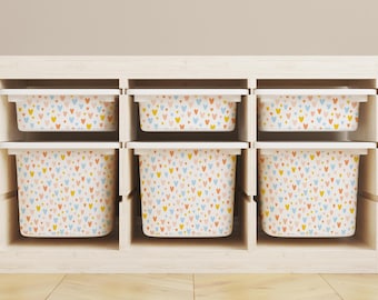 May include: Six white storage bins with a colorful heart pattern on a wooden shelf. The bins are arranged in two rows of three.
