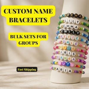Puede incluir: Una pila de pulseras de cuentas coloridas con cuentas de letras redondas que deletrean nombres como Gema, Lily, Emma, Emily, Bette, Dale, Mira, Iris, Sahra, Ruth y Aria. El texto CUSTOM NAME BRACELETS, BULK SETS FOR GROUPS y Fast Shipping es visible.