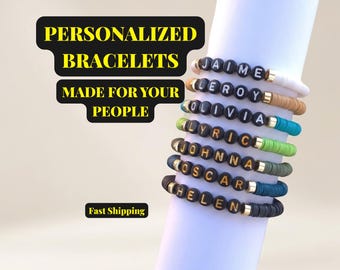 Könnte beinhalten: Eine Sammlung personalisierter Armbänder mit Namen, die in schwarzen Buchstabenperlen geschrieben sind. Die Armbänder sind in verschiedenen Farben erhältlich, darunter Weiß, Braun, Grün und Blau. Der Text "PERSONALIZED BRACELETS MADE FOR YOUR PEOPLE" ist im Bild zu sehen.