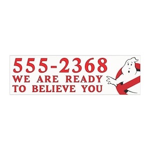 May include: A rectangular white sticker with red text and a cartoon ghost logo. The text reads "555-2368" above "WE ARE READY TO BELIEVE YOU". The ghost logo is a white cartoon ghost inside a red circle with a red line through it.