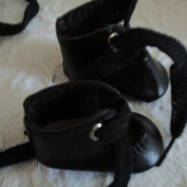 Vintage Black Leatherette Doll Shoes  String ties at Ankle  Shoes are 2 and 1/4 inches long and  1 and 1/8 inches wide.  Free Shipping