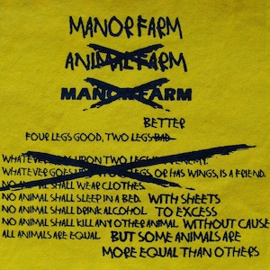 以下が含まれることがあります： 黄色い布地に黒い文字で「マナーファーム」と書かれており、その下に「アニマルファーム」が線で消されています。さらにその下に「マナーファーム」と書かれています。テキストは「Better Four Legs Good, Two Legs Bad」と続き、その下に線で消されたフレーズがあります。テキストは「Whatever goes upon two legs or has wings, is a friend. No animal shall wear clothes. No animal shall sleep in a bed. With sheets. No animal shall drink alcohol to excess. No animal shall kill any other animal without cause. All animals are equal but some animals are more equal than others.」と続きます。