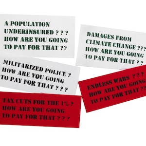 Può includere: Cinque cartelli rettangolari bianchi e rossi con testo nero. I cartelli hanno messaggi sul pagamento di cose come una popolazione, una polizia militarizzata, tagli fiscali per l'1%, danni causati dai cambiamenti climatici e guerre senza fine.