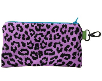 May include: A purple zippered pouch with a black leopard print design and a green zipper pull with a metal ring.