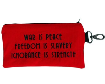 May include: Red zippered pouch with a black zipper and a black strap with a silver clip. The pouch has the text "WAR IS PEACE FREEDOM IS SLAVERY IGNORANCE IS STRENGTH" printed in black.
