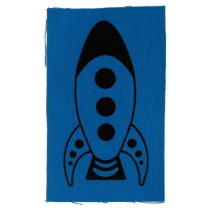 May include: A black rocket ship with three round windows on a blue fabric patch.