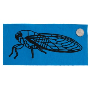 Puede incluir: Una silueta negra de una cigarra sobre un fondo de tela azul brillante.