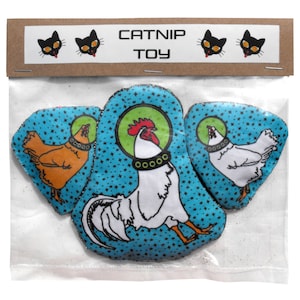 May include: A set of three catnip toys shaped like chickens. Each chicken is wearing a space helmet and has a different coloured body. The toys are packaged in a clear plastic bag with a brown header card that says "Catnip Toy".