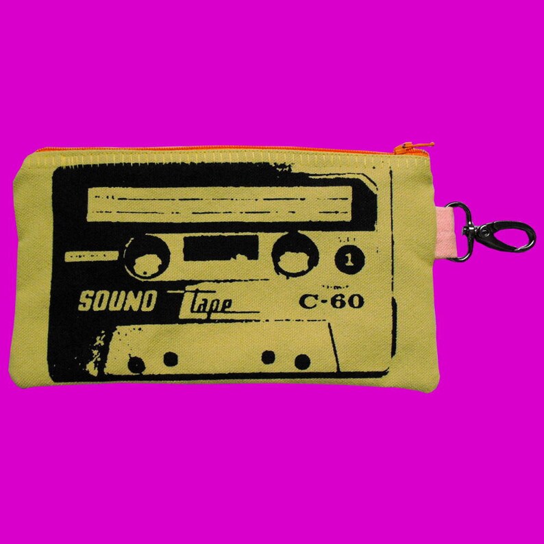 May include: A yellow canvas zippered pouch with a black and white graphic of a cassette tape. The tape reads "SOUND Tape C-60".