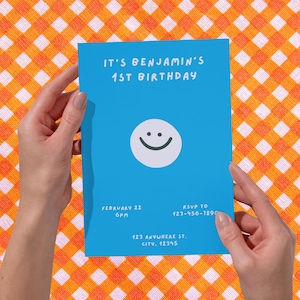 Può includere: Un invito di compleanno blu con la scritta "IT'S BENJAMIN'S 1ST BIRTHDAY" e una grafica con una faccina sorridente. L'invito include data, ora, informazioni RSVP e indirizzo. L'invito è tenuto su uno sfondo a scacchi arancione e bianco.