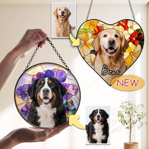 May include: Two stained glass pet portraits, one round and one heart-shaped, each featuring a dog's face. The round one has a Bernese Mountain Dog with purple flowers. The heart-shaped one has a Golden Retriever with the name "Bear" and the word "NEW".