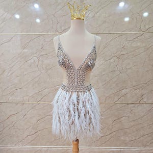 Luxury beaded mini dress with feathers. Skin-colored mini dress for parties. Custom mini dress for receptions