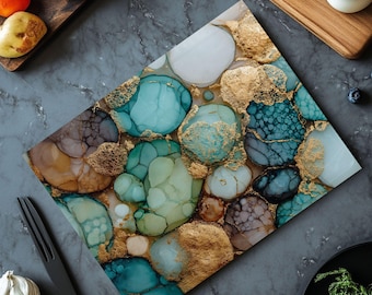 May include: Rectangular cutting board with an abstract design featuring teal, gold, and brown organic shapes. The board has a glossy finish and is surrounded by fresh produce and kitchen utensils.