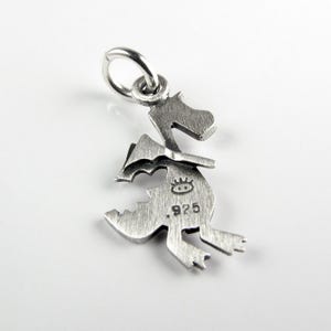 May include: A silver-colored metal charm shaped like a dragon hatching from an egg. The charm features a brushed finish, a small jump ring at the top, and is stamped with a small eye-like symbol and the number 925 on the front surface.