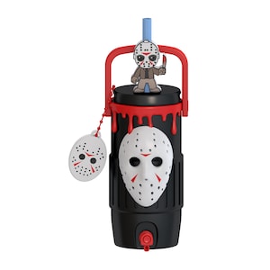May include: A black cylindrical tumbler featuring a white hockey mask emblem on the front, red dripping paint accents, a red handle, and a light blue straw. A small circular tag with a hockey mask design hangs from a red beaded chain on the side.