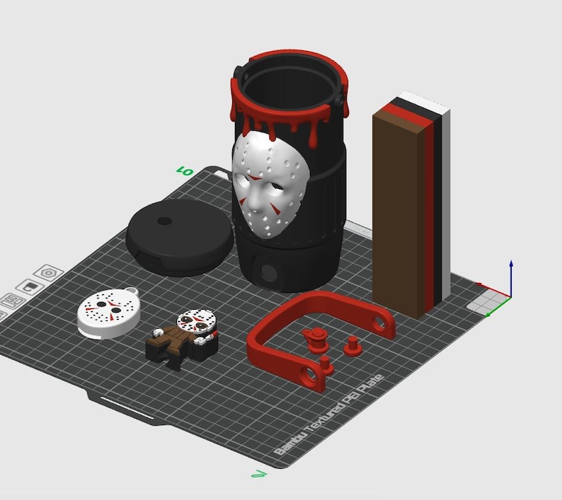 May include: A 3D printed set on a Bambu Textured PEI Plate including a black cylindrical container with a white hockey mask and red drip details, a small hockey mask pendant, a figurine, a red handle, and a rectangular block with brown, red, black, and white layers.