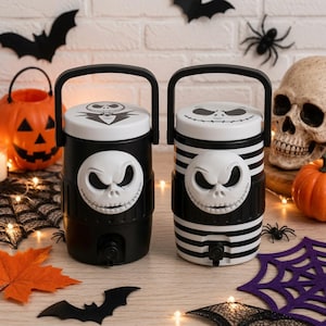 Pode incluir: Dois dispensadores de bebidas cilíndricos com alças de transporte e torneiras pretas. O dispensador esquerdo é preto sólido com um emblema branco do rosto de Jack Skellington. O direito apresenta listras horizontais pretas e brancas com rosto igual.