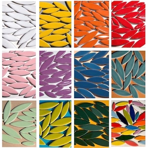 May include: A collection of leaf-shaped ceramic tiles in various colors, including white, yellow, orange, red, pink, purple, blue, teal, green, and a multi-colored arrangement. The tiles are arranged in a scattered pattern, showcasing their glossy finish.