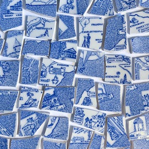 Op de afbeelding: Een verzameling gebroken keramische tegels met blauw-witte illustraties van kaarten en bezienswaardigheden. De fragmenten bevatten plaatsnamen zoals Richmond en Roanoke, waardoor een gefragmenteerd kaartontwerp ontstaat.