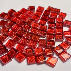 Peut inclure: Un ensemble de petits carreaux de mosaïque en verre rouge, de forme carrée. Les carreaux présentent une surface texturée et scintillante. Parfaits pour les projets d'artisanat ou les décorations, ils ajoutent une touche d'éclat.