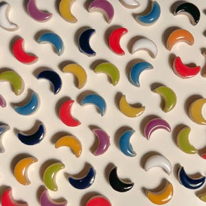 May include: Assortment of colorful ceramic crescent moon shapes in various colors including red, yellow, blue, green, purple, white, and black.